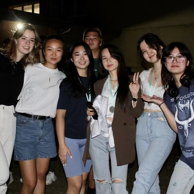 Group of young residents with medals posing together at an evening outdoor event